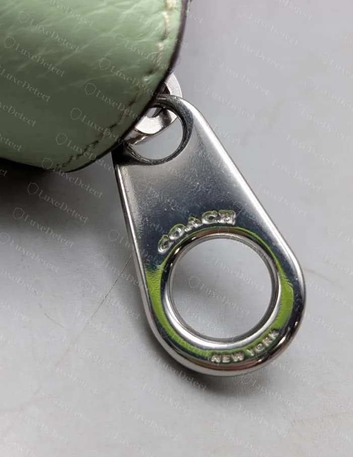 Modern Coach zip wallet: zipper pull stamped with COACH and NEW YORK around the ring