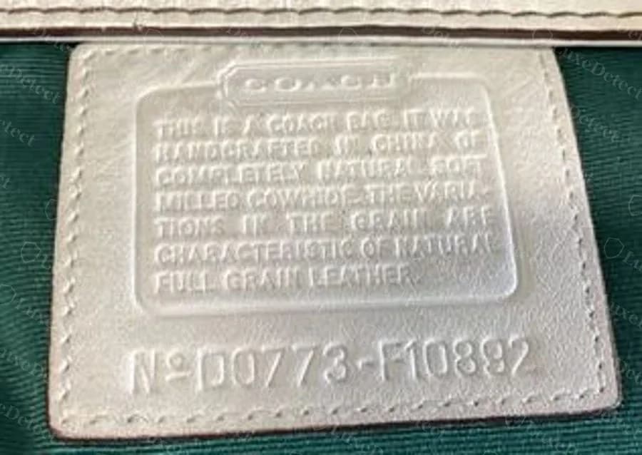 A genuine Coach creed patch in white leather: handcrafted-in paragraph in a bordered panel and the code N°D0773-F10892 pressed underneath, which reads April 2007, factory 73, outlet style F10892