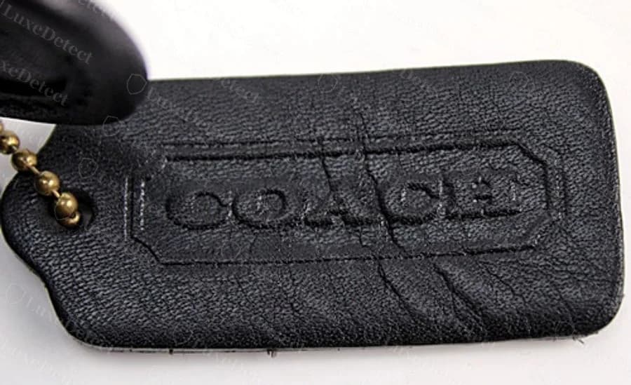 Authentic Legacy leather hangtag: sharp, evenly embossed COACH wordmark.