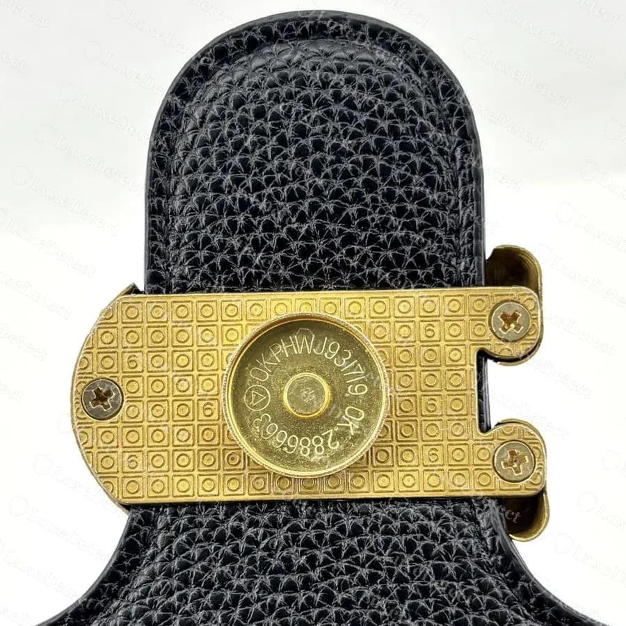 Back of the turnlock on a confirmed counterfeit Tabby: the backplate is covered in a raised grid of small squares with a repeated "6", while the centre disc copies a genuine-style "OK" engraving.