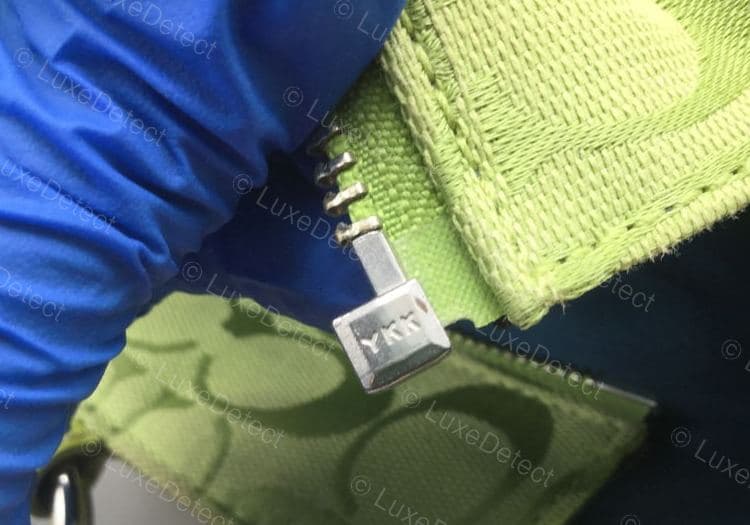 Tirador de cierre Coach original: la marca YKK estampada con claridad en el tope metálico de los dientes