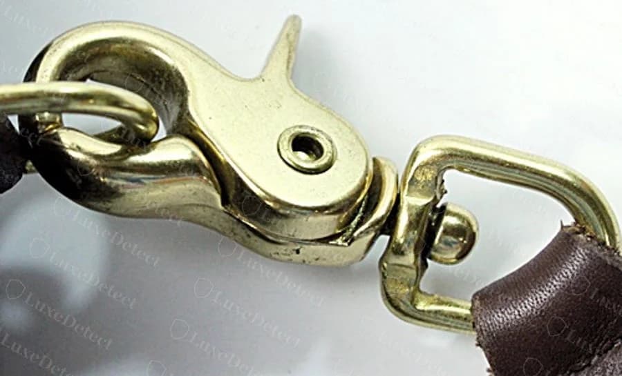 Genuine Willis strap hardware: a brass trigger-snap hook and swivel connector, showing the casting detail and rivet construction typical of this era's hardware.