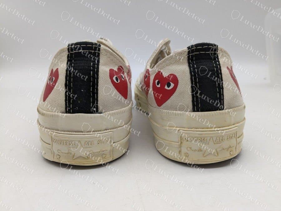 Comme des Garçons Play x Chuck 70 Ox falsa, vista posteriore: la striscia nera del tallone, l’intersuola egret e la placca del tallone Converse All Star in rilievo