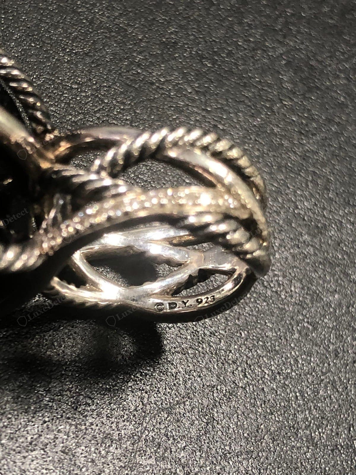 Cable David Yurman genuino: una hélice firme y uniformemente trenzada con un paso constante, vueltas nítidas y definidas y surcos limpios, peso macizo y un contraste "©D.Y. 925" estampado con nitidez