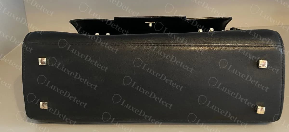 Genuine Delvaux Tempête base with four square metal studs near the corners