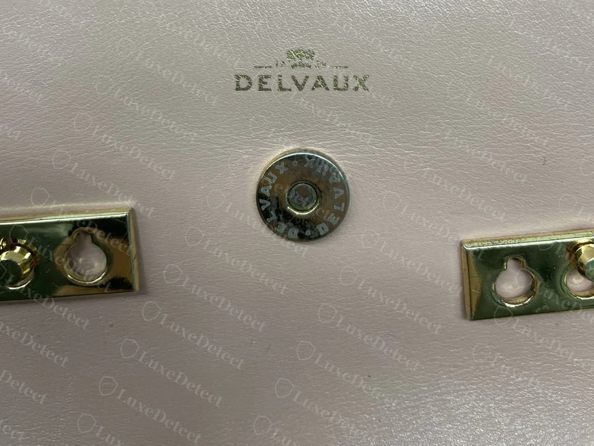 Counterfeit pink Delvaux Tempête with a snap engraved DELVAUX, a clean DELVAUX logo stamp and gold-tone keyhole plates
