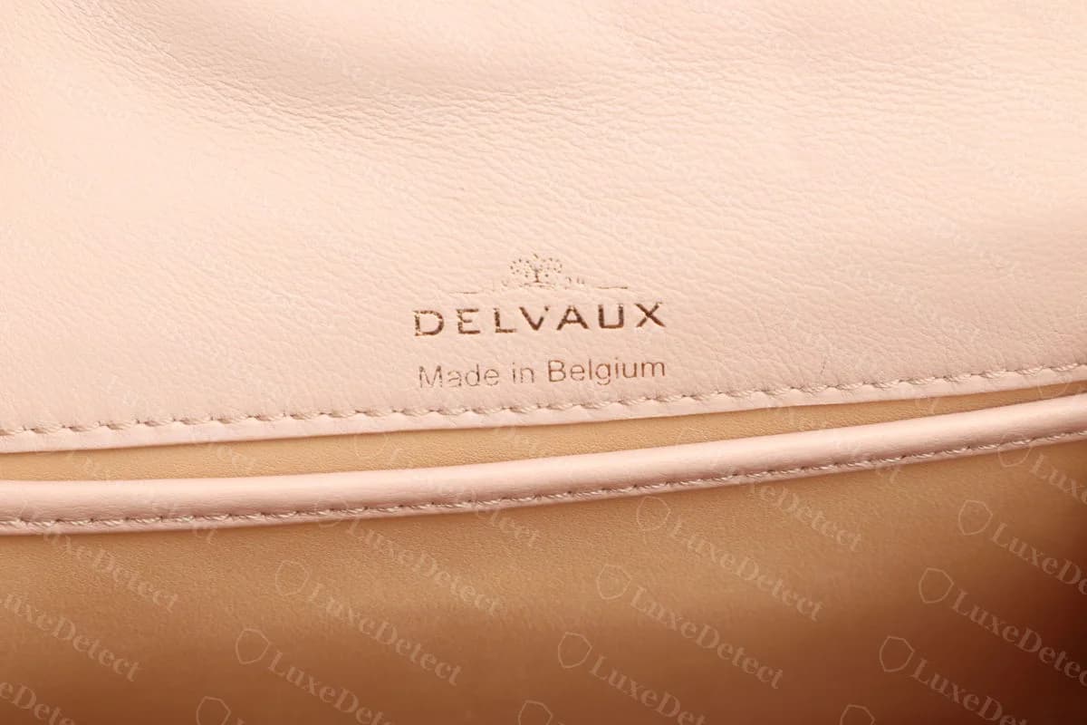 Genuine Delvaux Tempête interior stamp reading DELVAUX over Made in Belgium, on pale pink leather