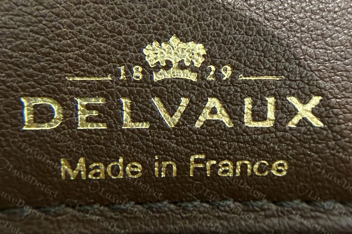 Genuine Delvaux Tempête interior stamp with the crown, 1829 and DELVAUX above Made in France in gold foil, next to the zipped pocket