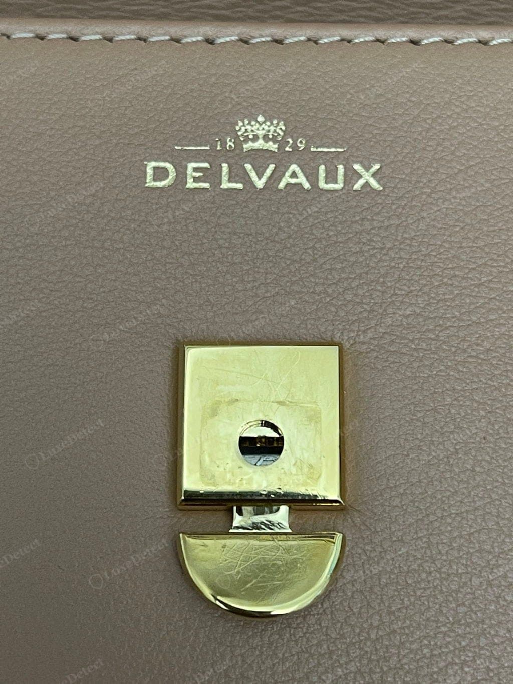 Costuras y canto genuinos de Delvaux: puntadas parejas de lino encerado mate, pespuntes rectos, canto abombado pintado a mano y liso