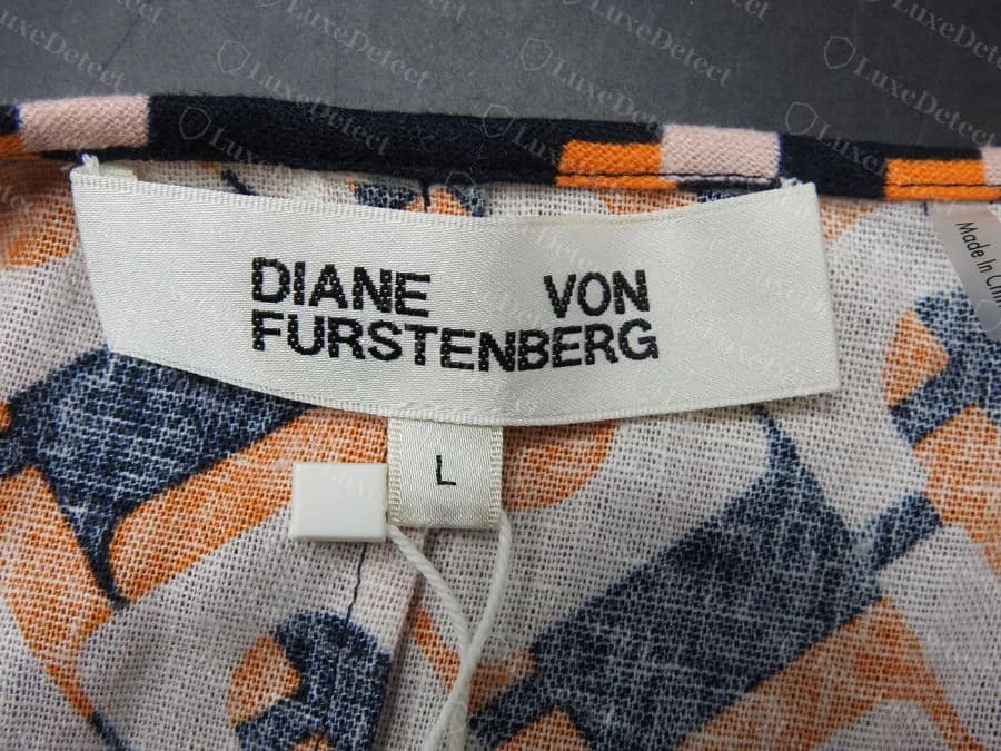 Etiqueta tecida branca Diane von Furstenberg original impressa em preto em negrito, com DIANE e VON na primeira linha e FURSTENBERG na segunda, e uma etiqueta de tamanho L abaixo
