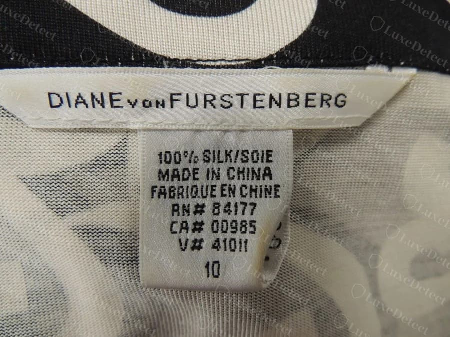 Etiqueta blanca tejida original de Diane von Furstenberg con 100 por ciento seda, hecho en China en inglés y francés, número RN 84177, número CA 00985, un número V y talla 10