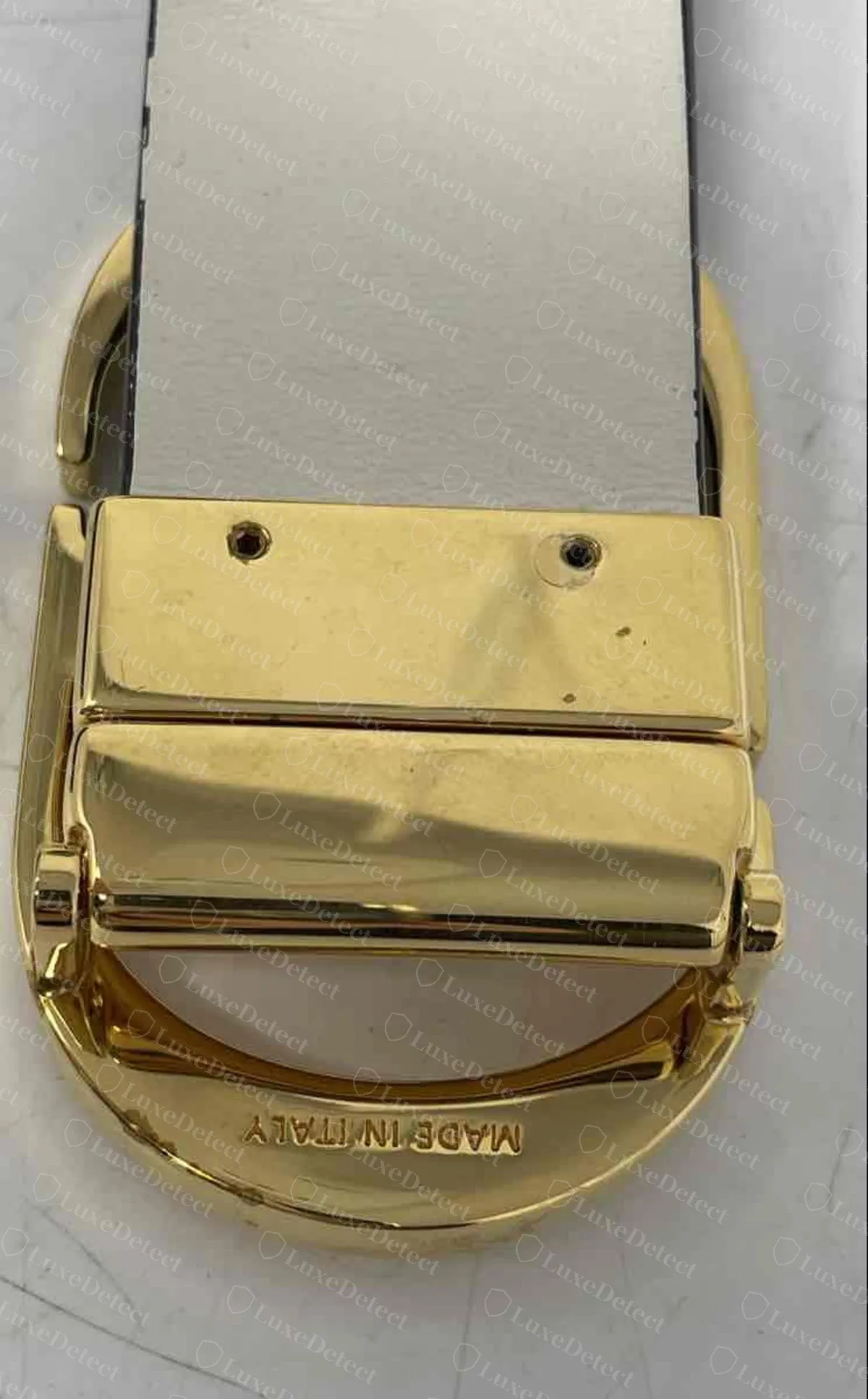 Genuine reversible 30 Montaigne belt, the gold hinge block behind the oval CD buckle with two screws holding the strap, a clean pivot pin and "MADE IN ITALY" engraved on the inside of the oval