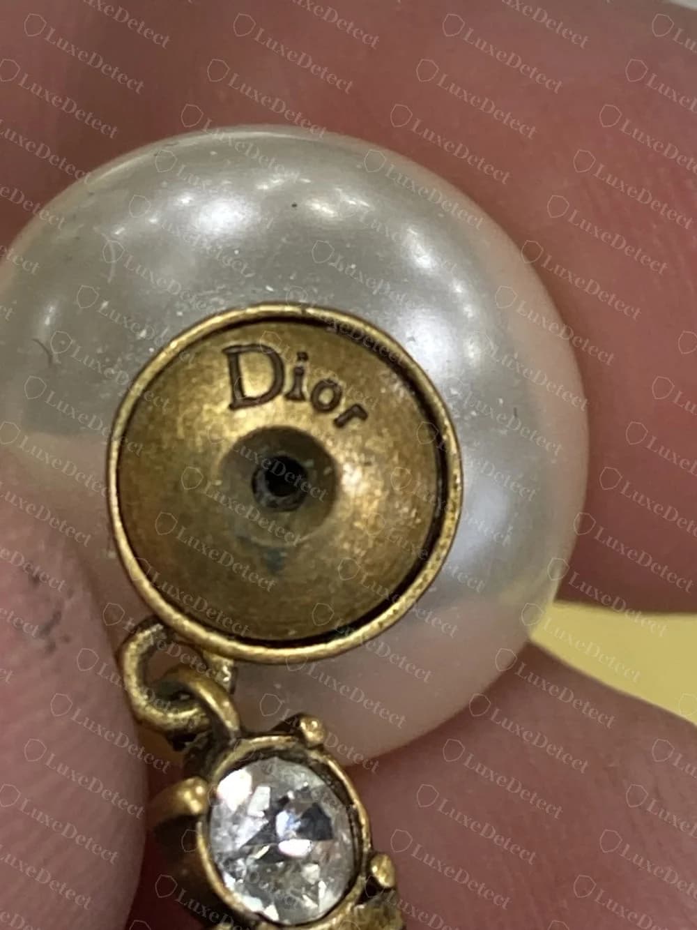 Boucle d'oreille à cristaux pendants J'Adior de Dior contrefaite avec « Dior » en écriture mêlant majuscule et minuscules sur la coupelle arrière derrière la perle