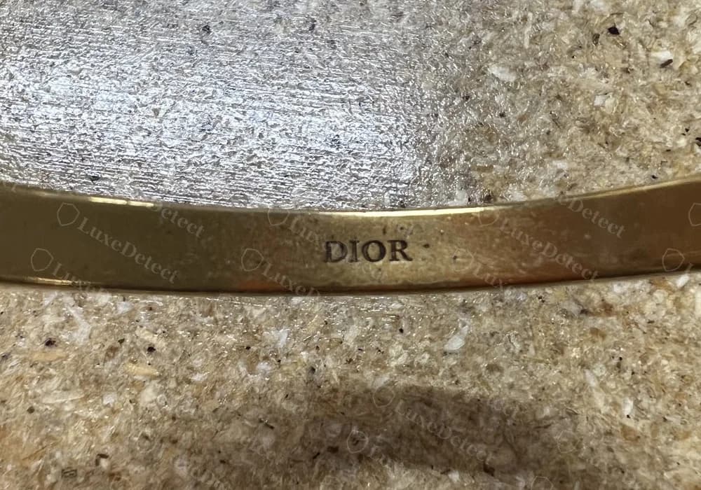 Brazalete J'Adior de Dior original: un pequeño "DIOR" bien estampado, en mayúsculas con remates, en el interior de la banda