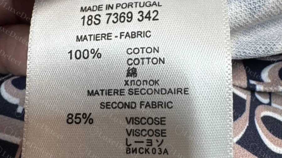 The same Made in Portugal label on a counterfeit Oblique-print piece, with the identical code and second-fabric block