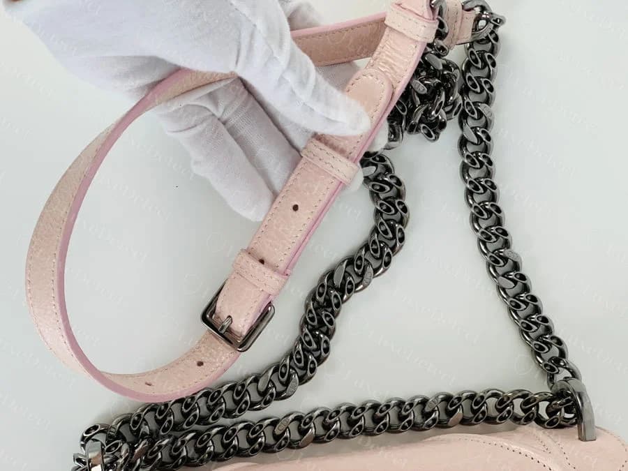 Dior Diorama chain strap with leather shoulder guard, chain links threaded through a stitched pink leather panel and gathered at a buckle