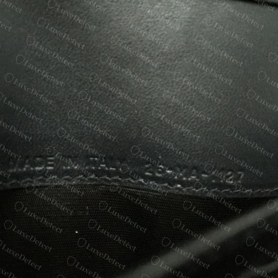 Dior Diorama interior heat stamp reading MADE IN ITALY with the atelier production code beneath it, embossed into the lining leather above the seam stitching