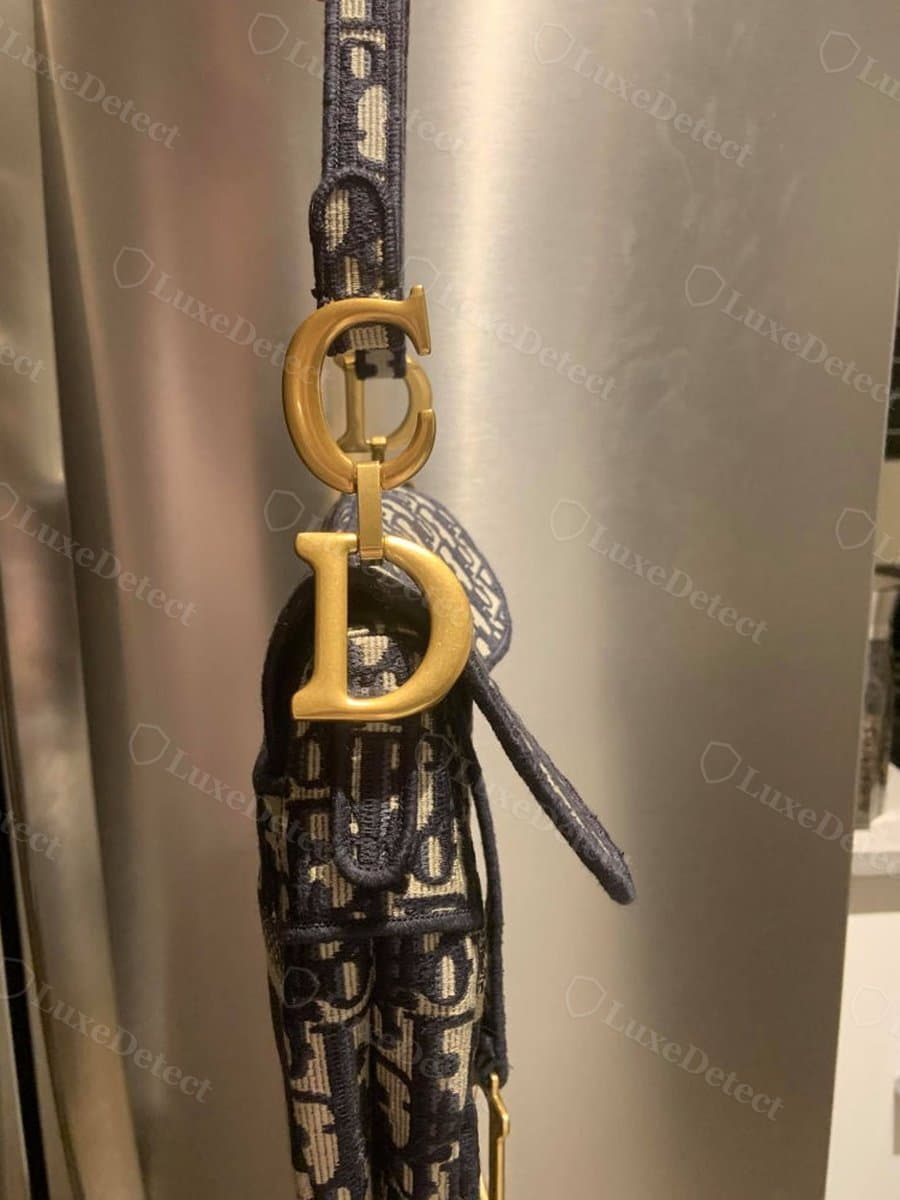 Counterfeit CD charm: a close copy of the proportions; weight and whether the D genuinely articulates on its link are tactile checks a photo cannot settle