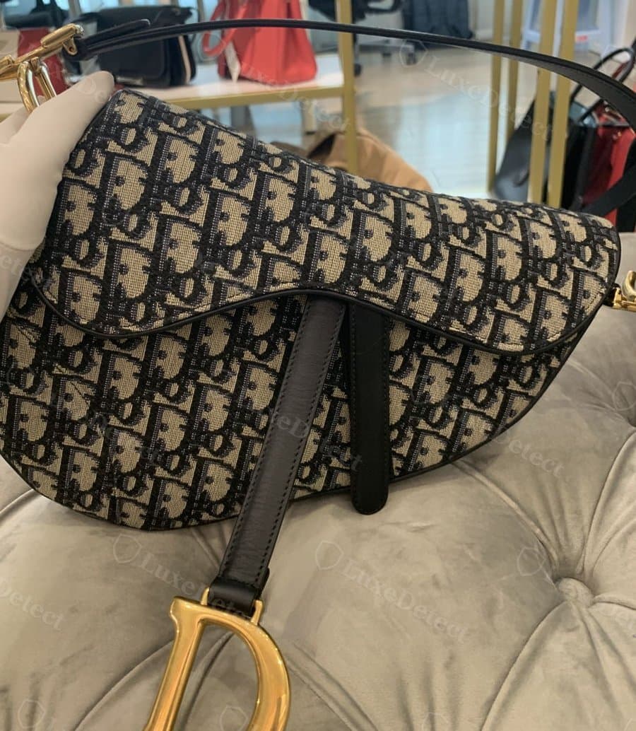 Authentic Saddle Bag, standard Oblique canvas: asymmetric D-curve, wider at the top right, curving cleanly to the bottom left