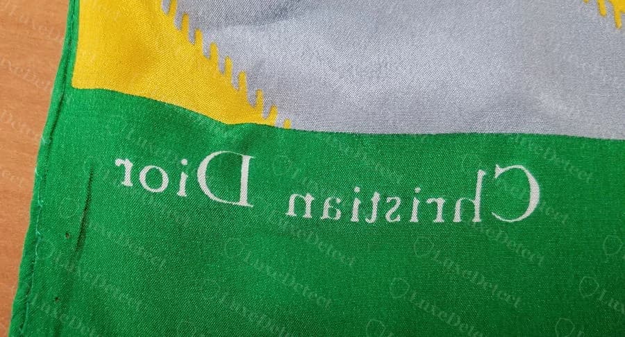 Counterfeit printed silk scarf from our sample: the "Christian Dior" signature is printed upside down relative to its panel, while the correct orientation appears elsewhere on the same scarf