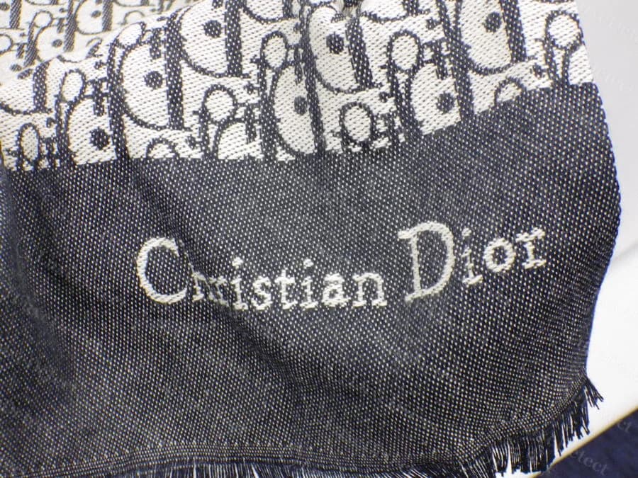 Counterfeit woven signature from our sample: "Christian Dior" with the h and r compressed together, legible at the other end of the same scarf but distorted here