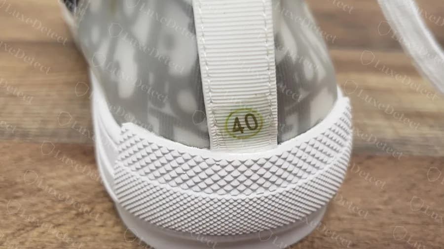 Dior B23 high-top falsificado con una pegatina de talla redonda y numerada en la lengüeta del talón