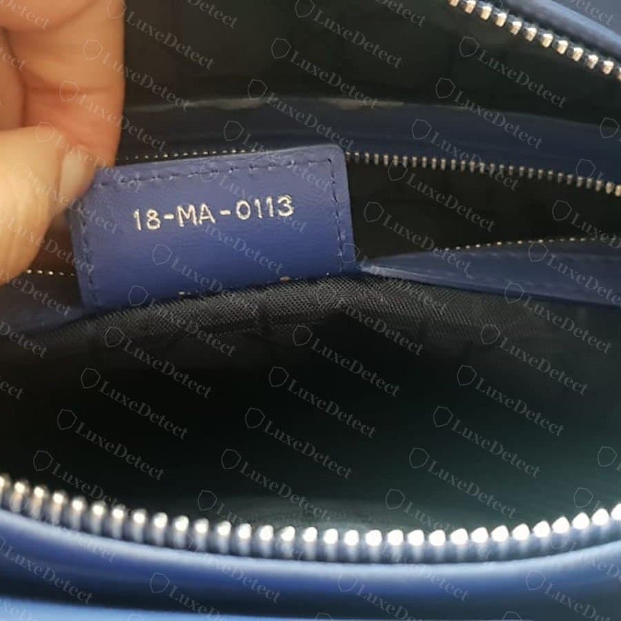 Code date Dior authentique estampillé sur une languette de cuir bleu cousue à l'intérieur d'un Lady Dior, à côté de la fermeture éclair intérieure