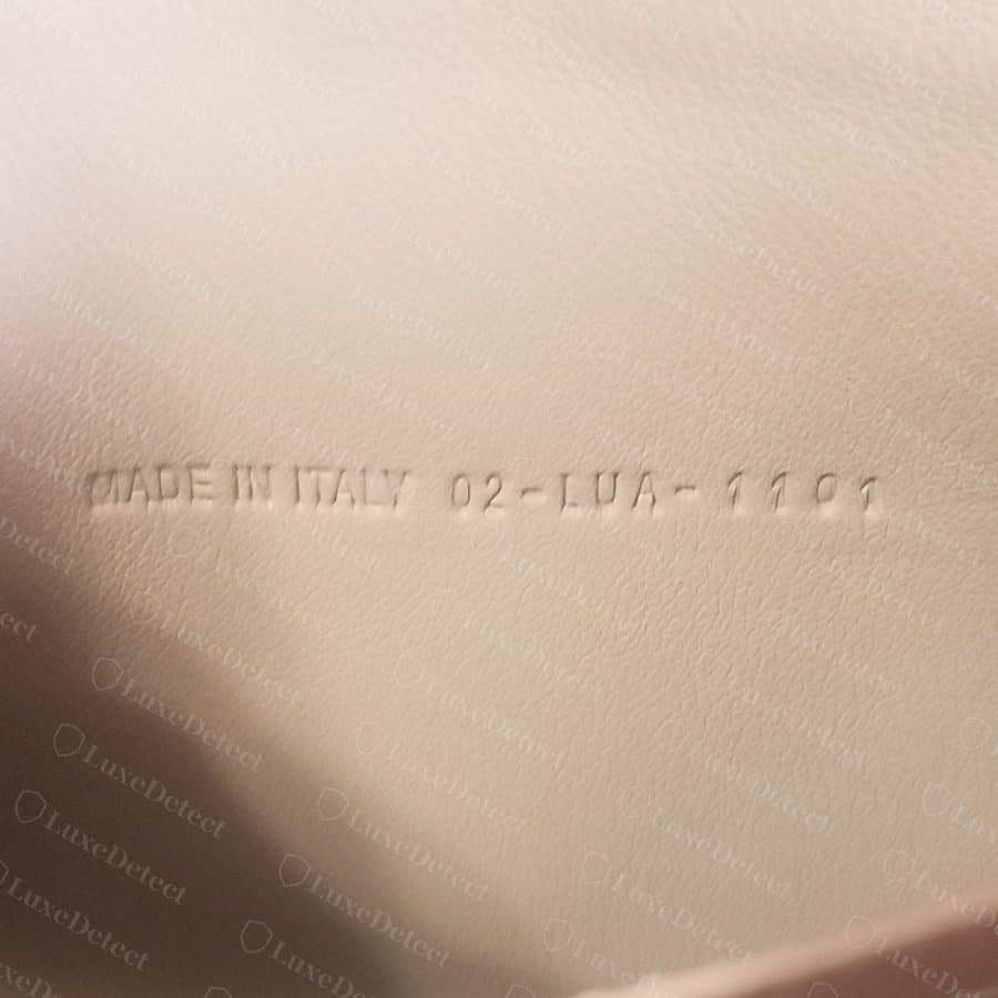Codice Dior autentico impresso senza inchiostro su una fodera di pelle chiara, con i caratteri sotto la superficie a profondità costante