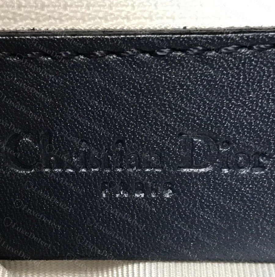 Punzone interno Christian Dior Paris autentico impresso a caldo su pelle blu navy, con le lettere pressate sotto la superficie