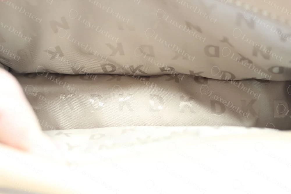 Genuine DKNY lining in tan satin-twill with a tonal repeat of the letters D K N Y woven into the fabric