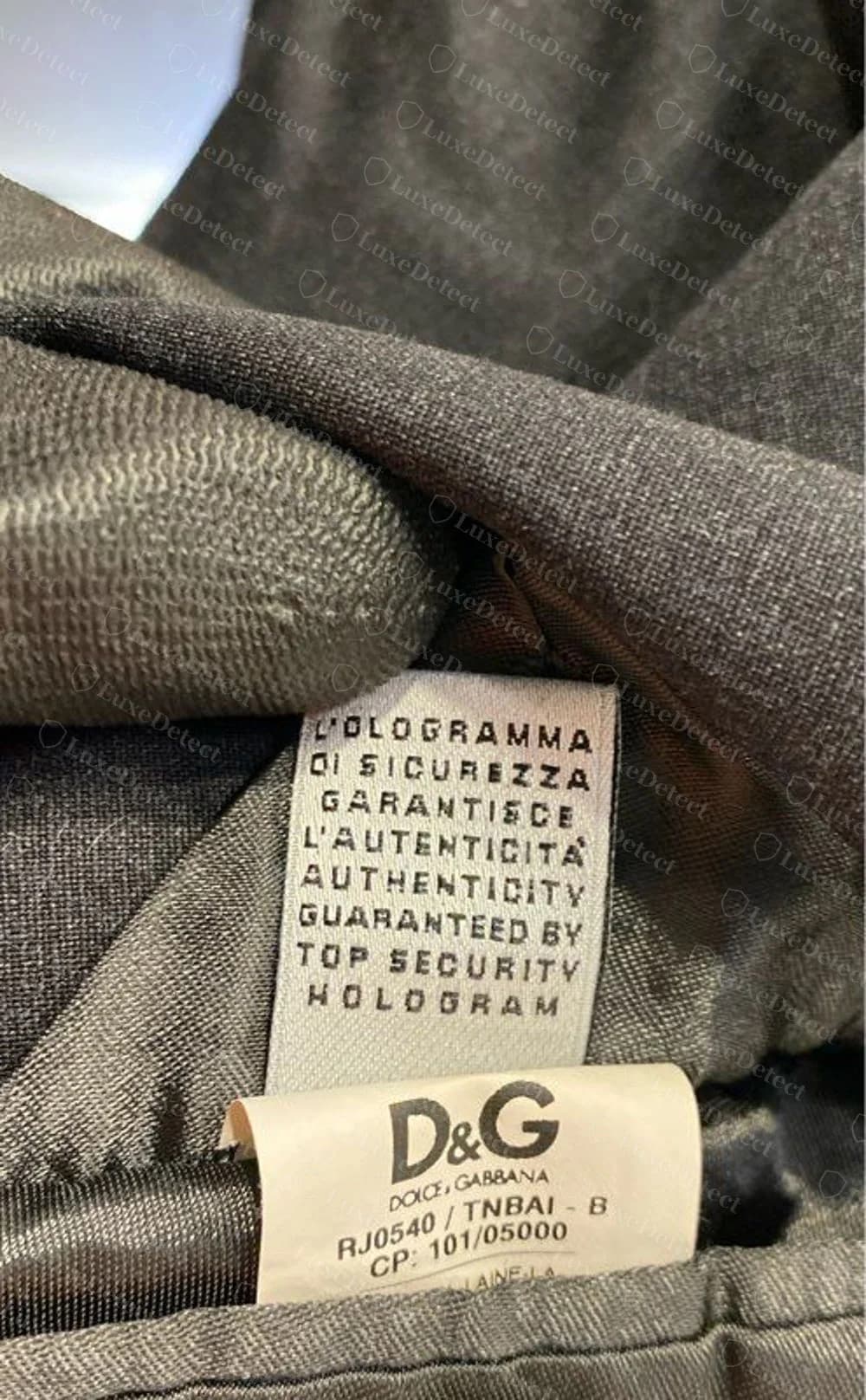 Genuine D&G-line label: a paper security-hologram tag ("l'ologramma di sicurezza garantisce l'autenticita") above a D&G label with the code RJ0540 / TNBAI - B and CP: 101/05000