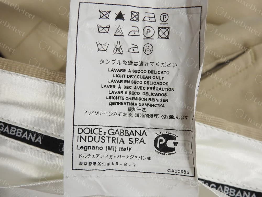 Etiqueta de cuidado Dolce&Gabbana original en unos pantalones: limpieza en seco ligera solamente en varios idiomas, DOLCE & GABBANA INDUSTRIA S.P.A. Legnano (Mi) Italy, una marca de certificación rusa, la dirección del importador japonés y CA00985