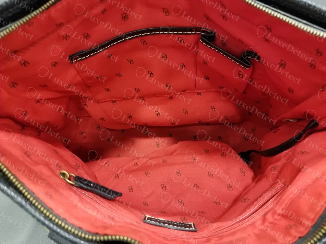 Bolso Signature falso: un forro rojo estampado con pequeños logos DB negros en ángulos dispersos, tanto en el bolsillo como en el cuerpo