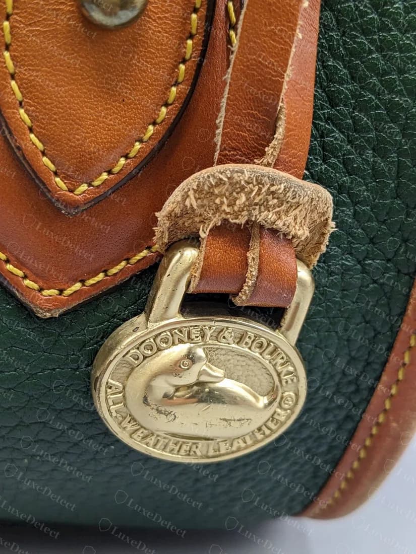 Echter massiver Enten-Anhänger aus Messing an einer grünen All-Weather-Leather-Tasche, mit DOONEY & BOURKE und ALL-WEATHER LEATHER rund um die Ente