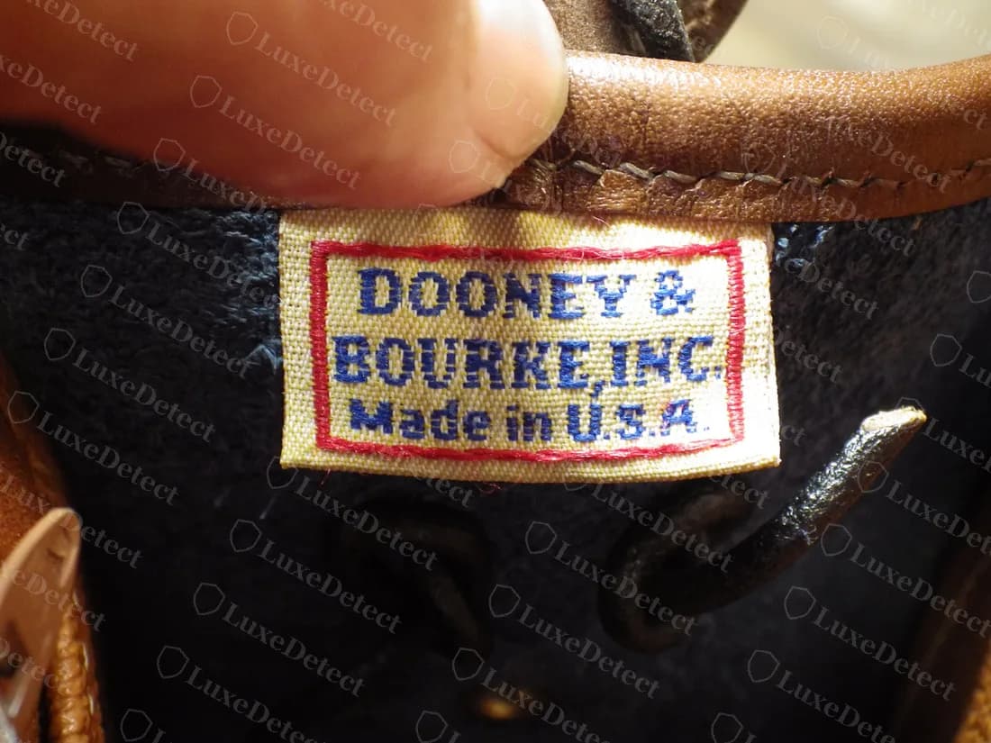Echtes Vintage-Etikett All-Weather Leather: ein gewebtes, rot umrandetes Etikett DOONEY & BOURKE, INC. Made in U.S.A. in blauer Schrift