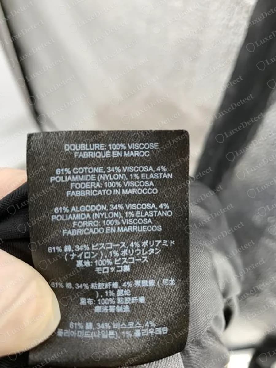 Genuine Dries Van Noten black woven care label in French, Italian, Spanish, Japanese, Chinese and Korean giving fibre content and a Made in Morocco line