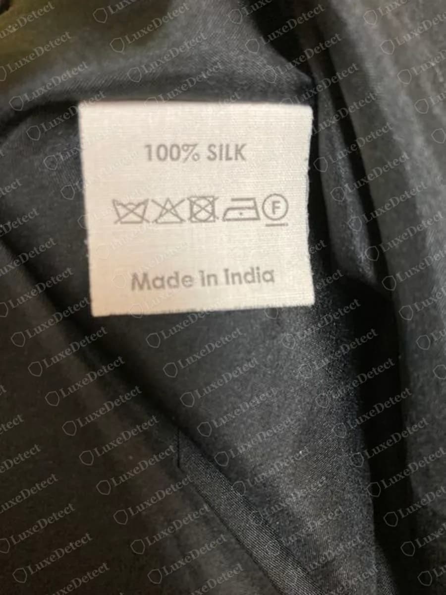 Genuine Dries Van Noten white care label reading 100% SILK with wash symbols and Made in India