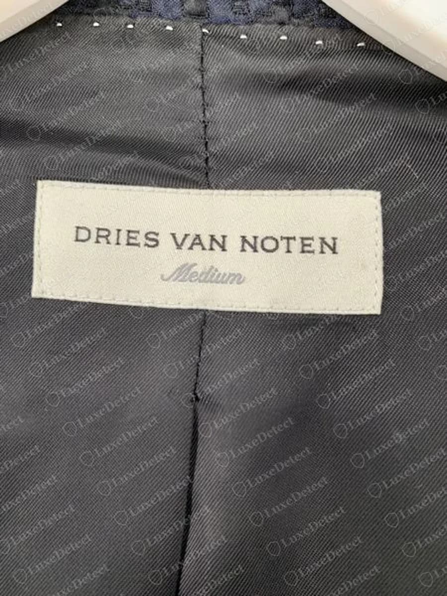 Genuine Dries Van Noten woven label on a navy blazer lining: cream label with DRIES VAN NOTEN in dark capitals and the size Medium in grey script beneath
