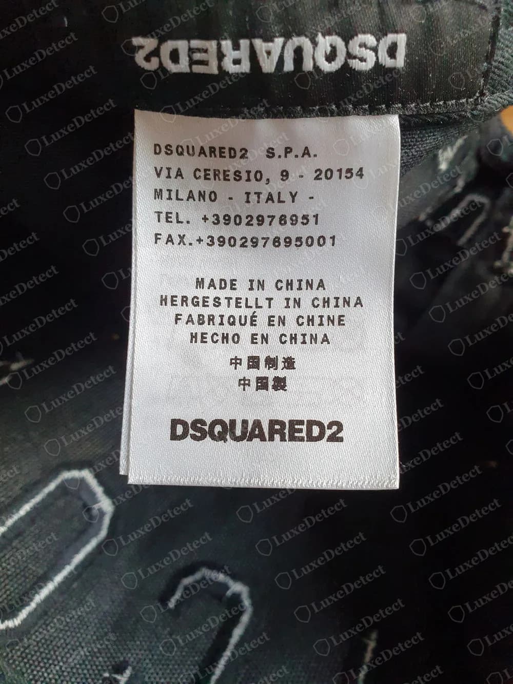 Genuine Dsquared2 black cap interior: DSQUARED2 woven label above a white label with the company name and Milan address, a MADE IN CHINA block in four languages and Chinese characters, and DSQUARED2 at the foot