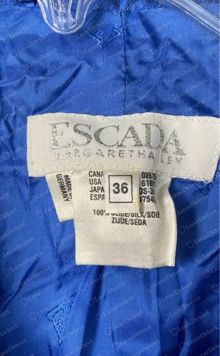 Genuine Escada cream woven label with silver lettering reading ESCADA over MARGARETHA LEY, with MADE IN GERMANY running vertically on the left and a size 36 box beside CANADA, USA, JAPAN and ESPA columns, above a fibre line reading 100% SEIDE/SILK/SOIE, on a blue lining