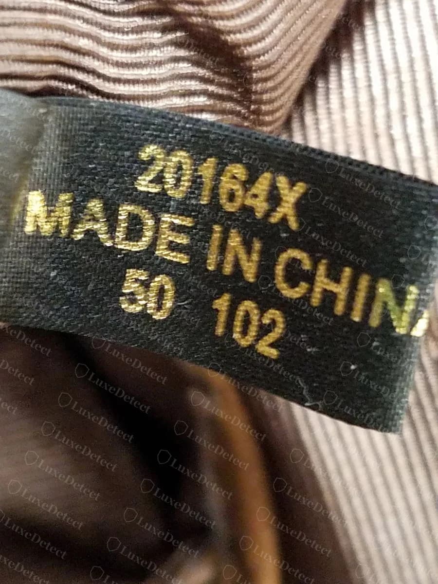 Etiqueta tecida preta Etienne Aigner original com impressão dourada: 20164X, MADE IN CHINA e os números 50 102