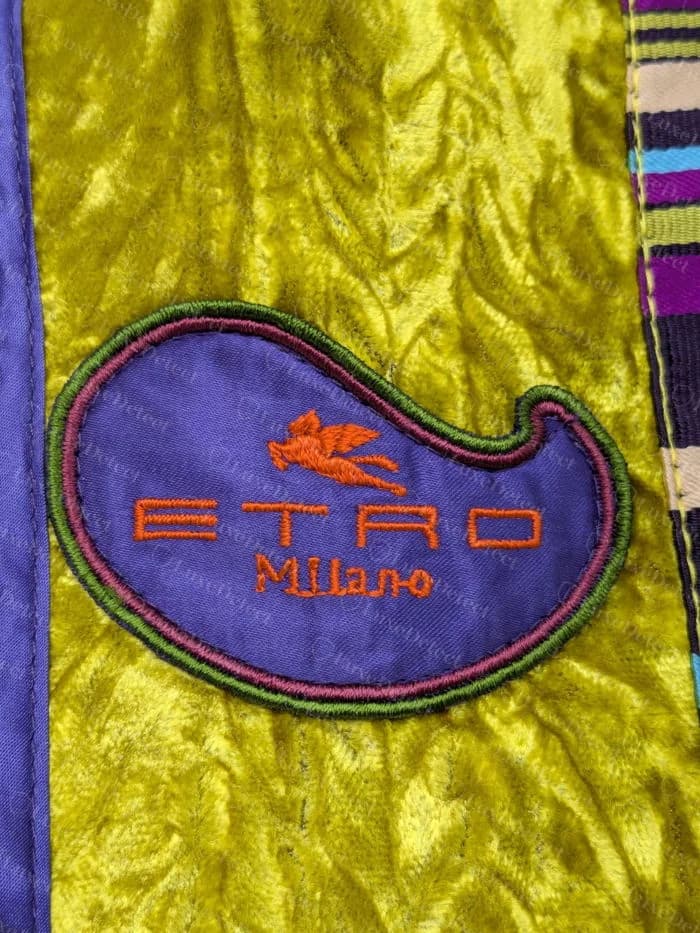Genuine Etro purple paisley-shaped embroidered patch with orange winged horse and ETRO Milano lettering, sewn onto a yellow crinkled lining