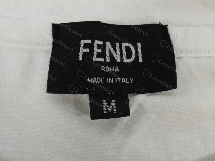 Etiqueta de gola de uma camiseta Fendi falsificada com uma etiqueta preta de tamanho M separada pendurada sob a etiqueta