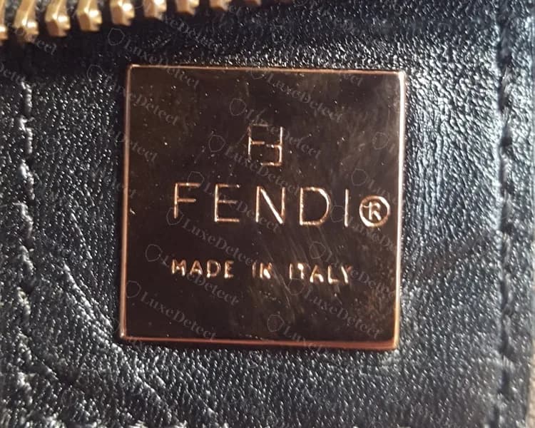 Genuine Zucca bag interior plate: a square metal plate on a black leather tab, an FF symbol over FENDI with the registered mark and MADE IN ITALY below