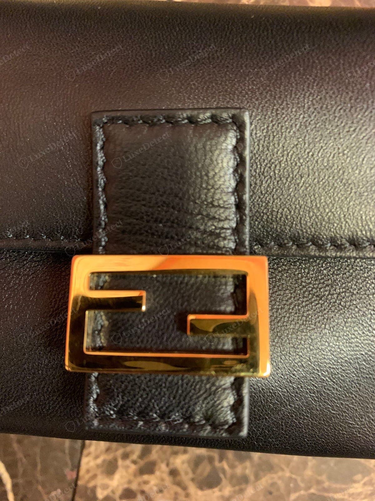 Genuine Fendi Baguette — the Zucca FF motifs identical in size and stroke weight, evenly spaced, the applied metal FF logo crisply cast and centred