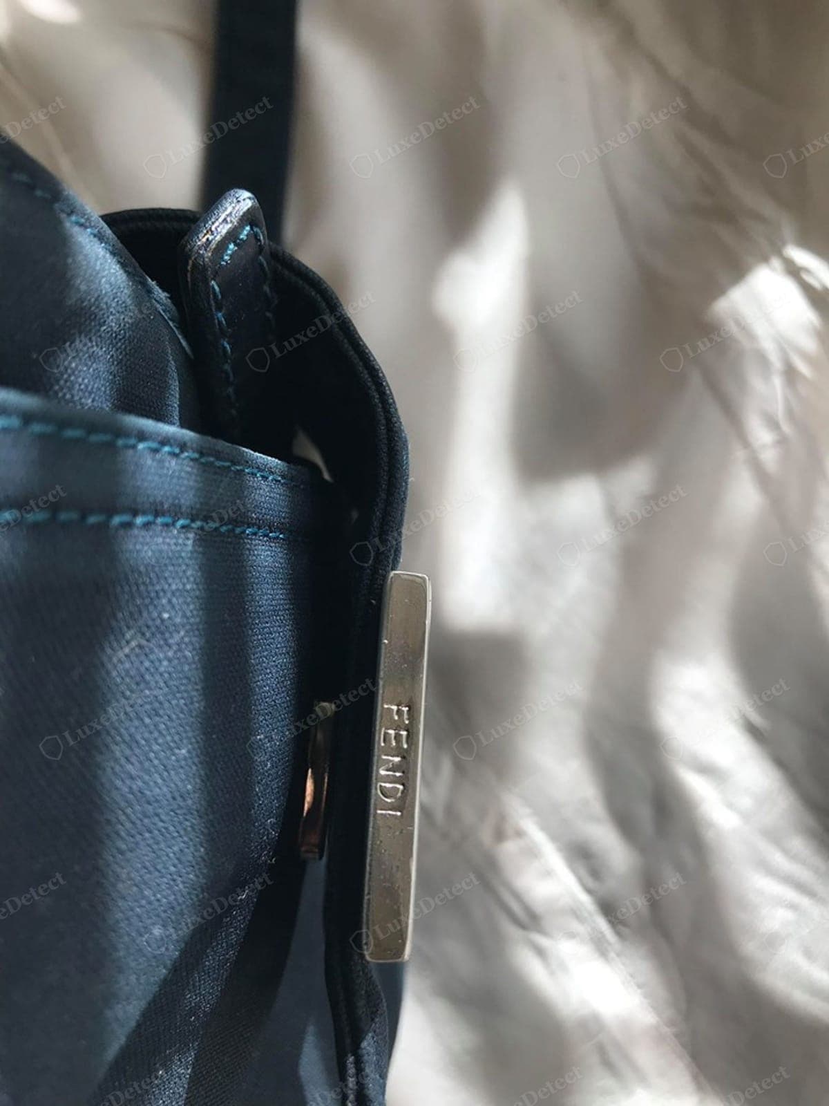 Genuine Fendi Baguette hardware — a solid cast buckle / FF clasp with a crisp "FENDI" engraving, even plating consistent across every piece on the bag