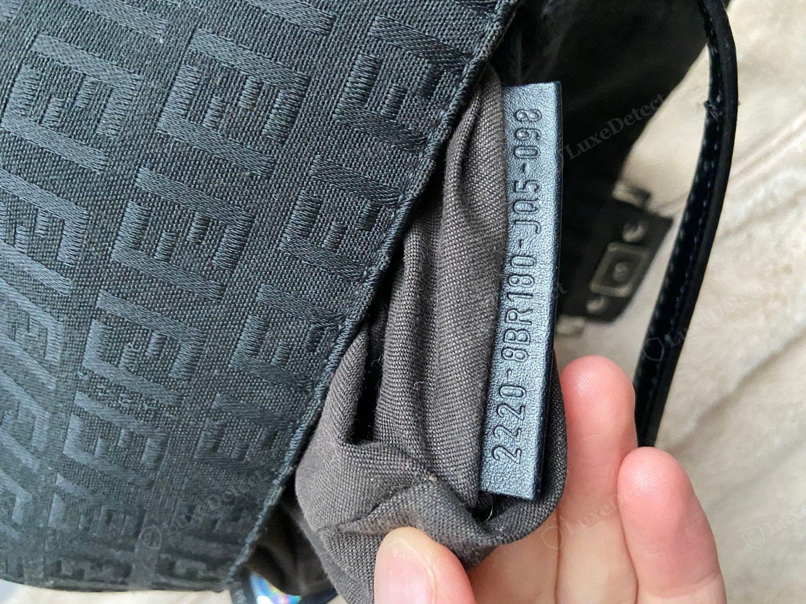 Counterfeit Fendi Baguette serial embossing — a shallow, blobby, or wrong-font stamp, an uneven baseline, or "Made in Italy" mis-styled