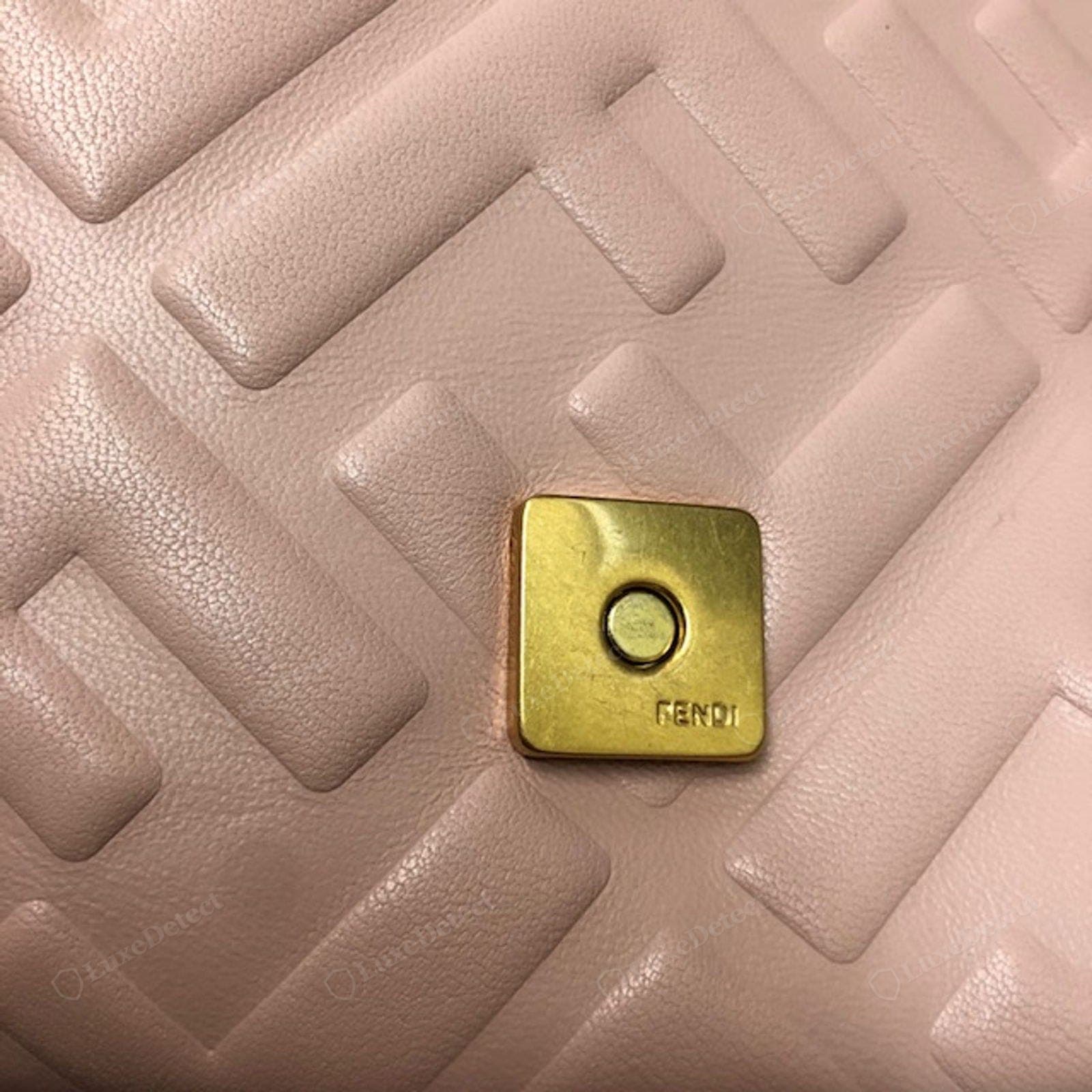 Counterfeit Fendi Baguette snap closure — a weak single-click snap, the flap not seating flush, or an exposed cheap popper