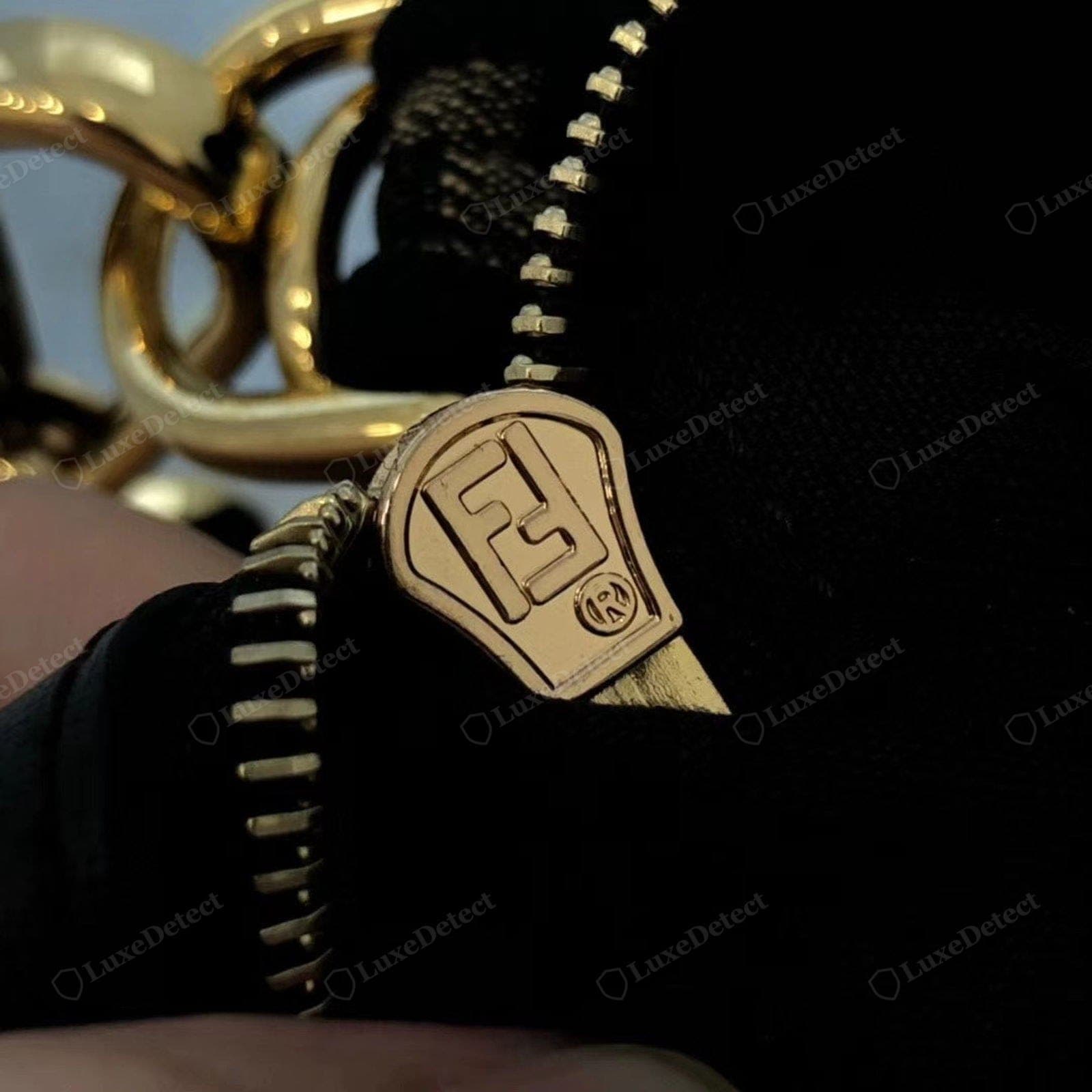 Counterfeit Fendi Baguette zipper — a soft or wrong-font stopper mark, a gritty action, tape in a mismatched colour