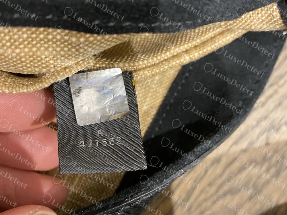 A etiqueta com holograma de uma bolsa Fendi falsificada: um adesivo prateado enrugado sem o motivo FF arco-íris, e o número A 497663 impresso embaixo